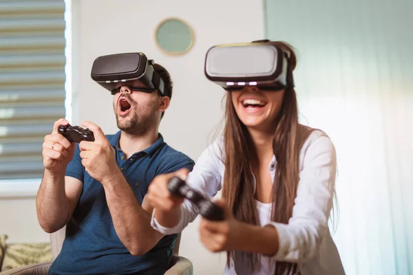 Unga lyckliga par som spelar video spel Virtual Reality glasögon. — Stockfoto
