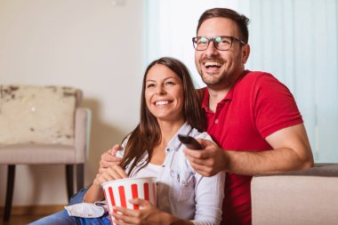 Aşık çift bir oturma odası kanepede oturan, Tv ve ea izlerken