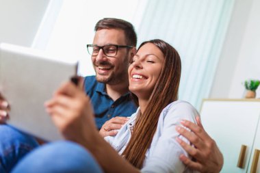 Genç çift li bir tablet te medya içeriği online izliyor