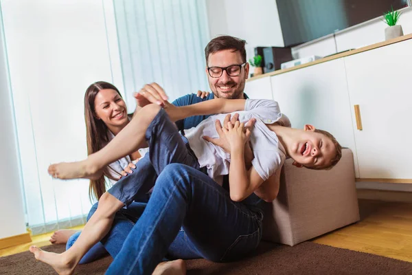 Lächelnde junge Eltern und ihr Kind sind sehr glücklich, sie sind ein — Stockfoto