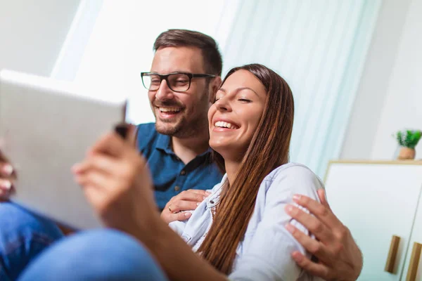 Young couple watching media content online in a tablet in the li — Stock Photo, Image