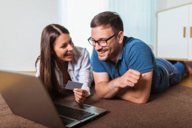 Dizüstü bilgisayar ve kredi veya banka kartı shoppin ile Gülümseyen mutlu çift