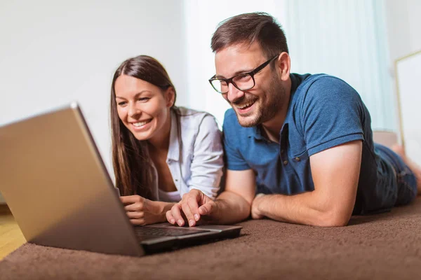 Smiling happy couple with laptop and credit or bank card shoppin — Stock Photo, Image