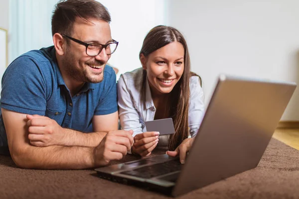 Sonriendo feliz pareja con ordenador portátil y de crédito o tarjeta bancaria shoppin —  Fotos de Stock