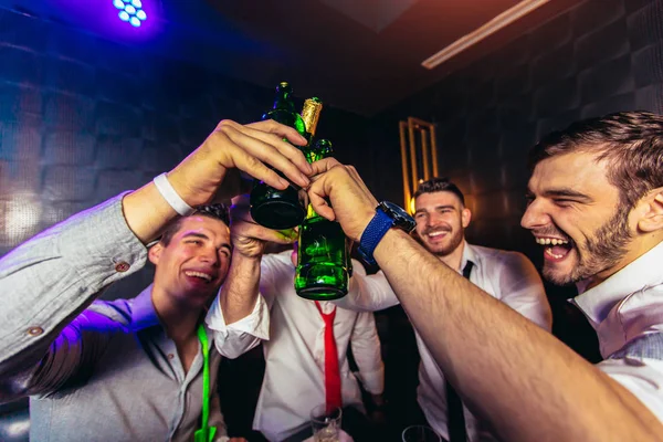 Groep van jonge mannen roosteren in een nachtclub — Stockfoto