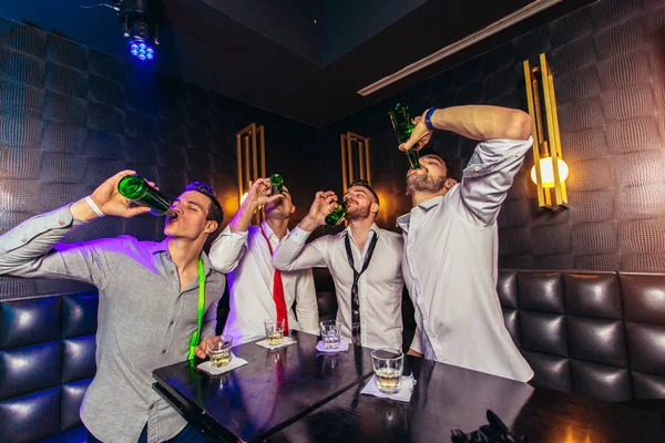 Skupina mladých mužů opékání v nočním klubu — Stock fotografie