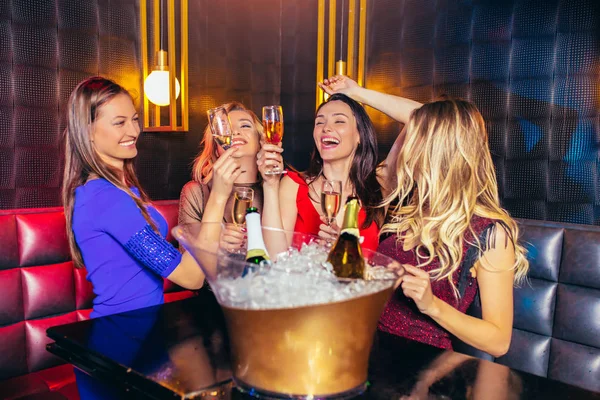 Donne felici clinking bicchieri di champagne e festeggiare di notte — Foto Stock