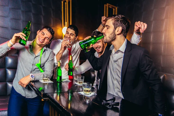 Группа молодых людей, пьющих тосты в ночном клубе — стоковое фото