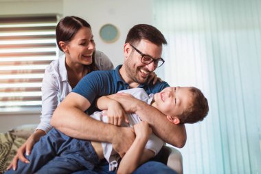 Gülümseyen genç ebeveynler ve çocukları çok mutlu, onlar bir
