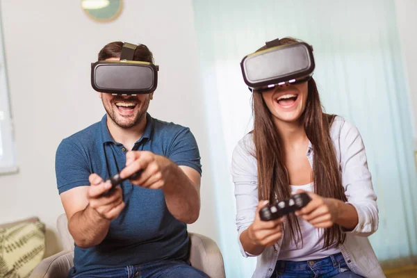 Unga lyckliga par som spelar video spel Virtual Reality glasögon. — Stockfoto