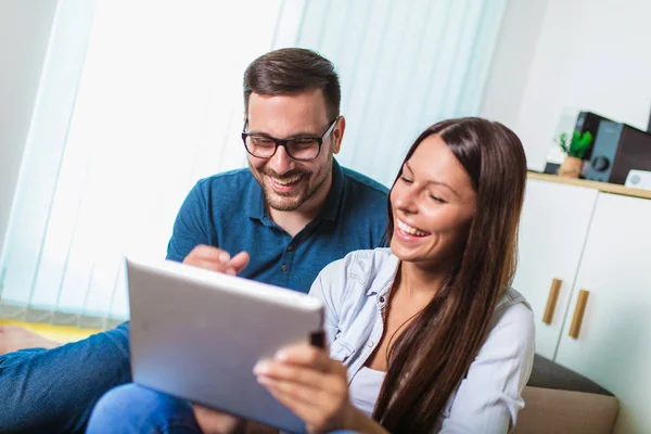 Young couple watching media content online in a tablet in the li — Stock Photo, Image