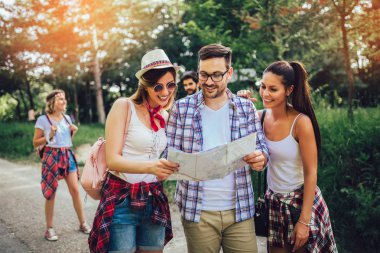 Ormanda sırt çantaları ile yürüyüş gülümseyen arkadaşlar grubu-Adven