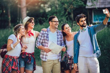 Ormanda sırt çantaları ile yürüyüş gülümseyen arkadaşlar grubu-Adven