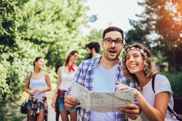 Group of smiling friends walking with backpacks in woods - adven — Stock Photo, Image