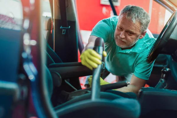 L'uomo pulisce l'interno della sua auto con l'aspirapolvere — Foto Stock