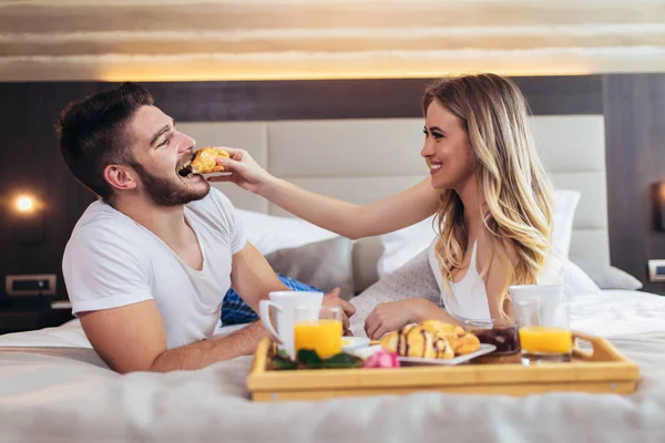 年轻幸福的夫妇在豪华酒店房间吃早餐. — 图库照片