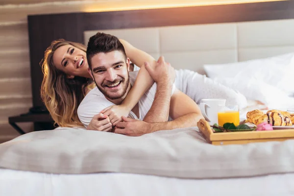 Young happy couple having breakfast in luxury hotel room. — Stock Photo, Image