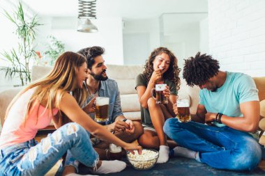 Patlamış mısır yeme ve içme bira bardağı evde, arkadaşlar eğlenmeye