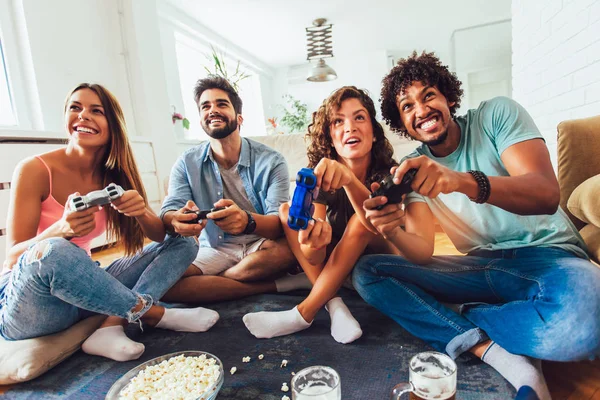 Grupo de amigos juegan videojuegos juntos en casa, divirtiéndose. —  Fotos de Stock