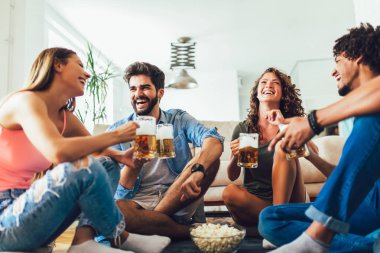Patlamış mısır yeme ve içme bira bardağı evde, arkadaşlar eğlenmeye