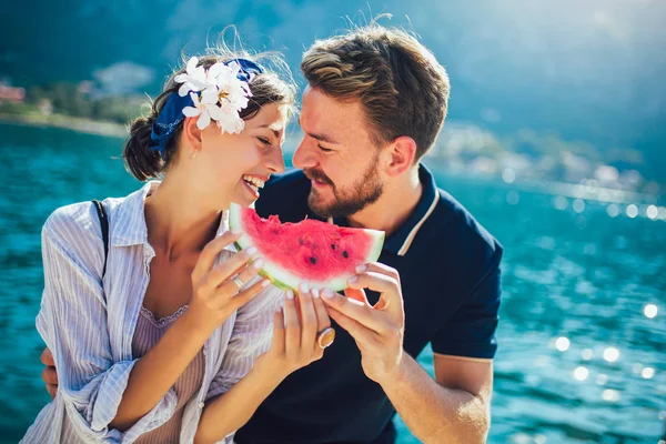 Vrolijk paar met plakjes watermeloen — Stockfoto