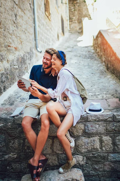 Romantisches Touristenpaar sitzt mit digitalem Tablet auf Treppe. — Stockfoto