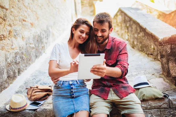 Romantiskt turist par sitter på trappor med hjälp av digital tablett. — Stockfoto