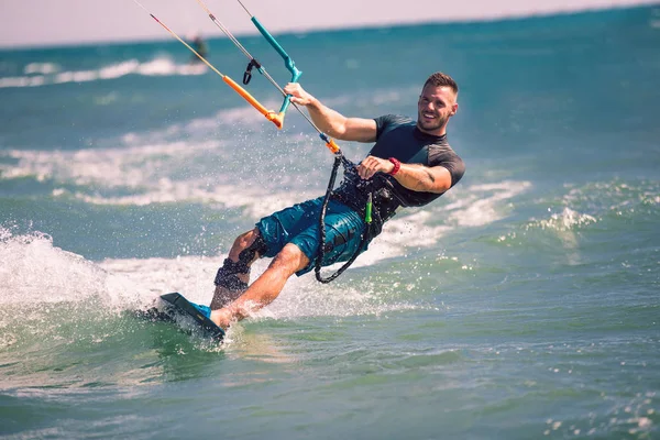 Kitesurfen. Man rijdt op vlieger op golven — Stockfoto