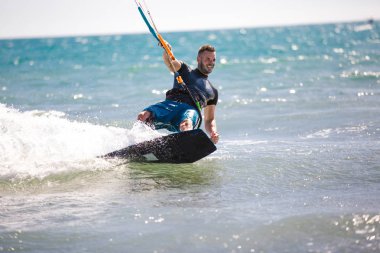 Uçurtma. Dalgalarda uçurtma süren bir adam