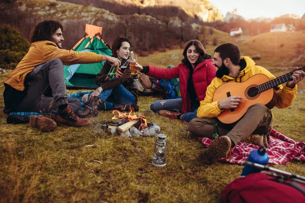 Gruppe lächelnder Freunde am Lagerfeuer im Zelten — Stockfoto