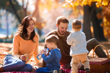 mutlu bir aile dört eğlenceli birlikte parkta sonbaharda sahip.