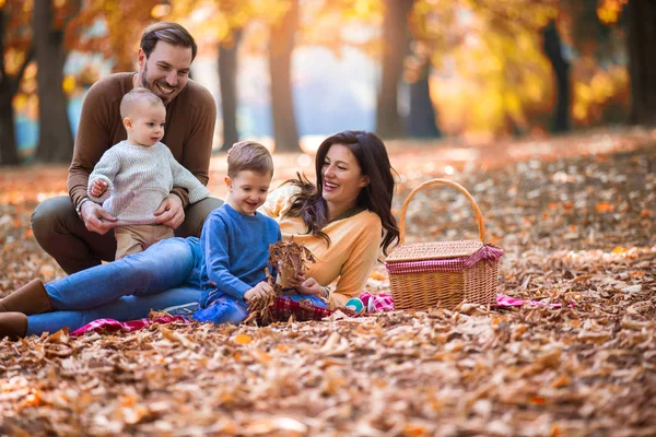 Glückliche vierköpfige Familie, die sich im Herbst im Park vergnügt — Stockfoto