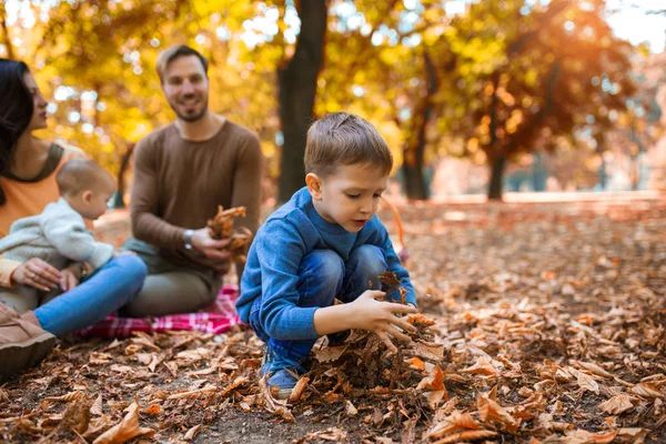 Щаслива сім'я з чотирьох розважається разом у парку восени — стокове фото