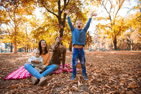 Glückliche vierköpfige Familie, die sich im Herbst im Park vergnügt — Stockfoto