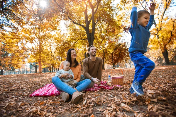 Família feliz de quatro se divertindo juntos no parque no outono — Fotografia de Stock