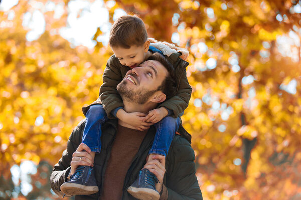 Happy father and little son playing and having fun outdoors over