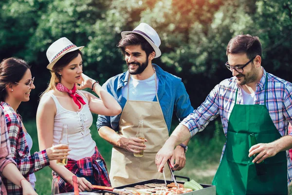 Jonge vrienden met plezier grillen vlees genieten van barbecuefeest. — Stockfoto