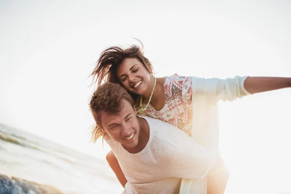 Casal jovem desfrutando de férias de verão. Bonito jovem dando — Fotografia de Stock