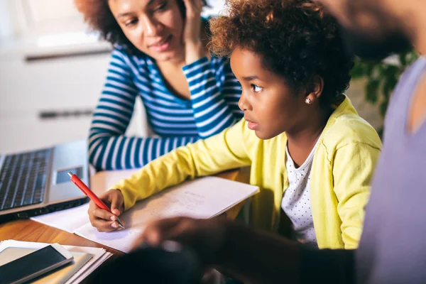 Madre y padre ayudando a su hija a hacer la tarea de aprender a ca — Foto de Stock