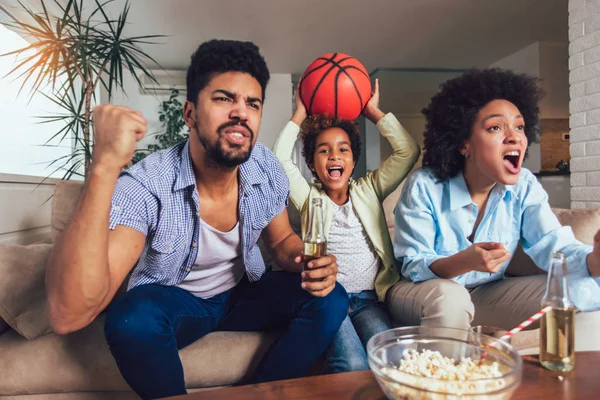 Felice famiglia afroamericana di tre guardare la tv e tifo — Foto Stock