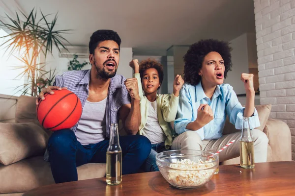 Felice famiglia afroamericana di tre guardare la tv e tifo — Foto Stock