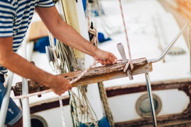 Olgun adam bir vinç kullanarak teknesinin güvertesinde duran süre 