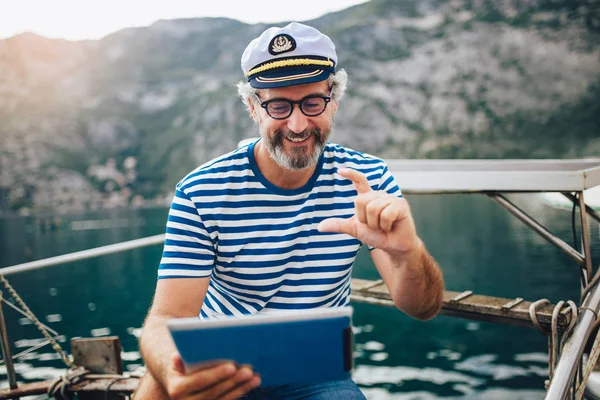 Dospělý muž stojící na palubě své lodi a používá digitální tu — Stock fotografie