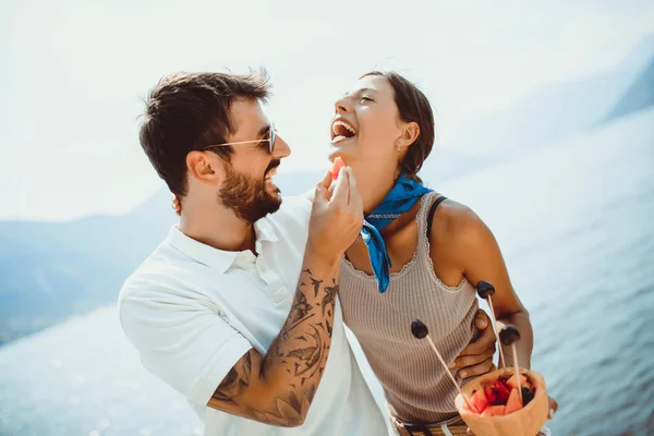 Jong stel het eten van fruit op het strand-zomerfeest met vriend — Stockfoto