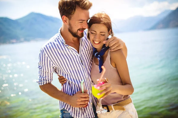 Mooi paar met plezier op het strand, cocktails drinken en — Stockfoto