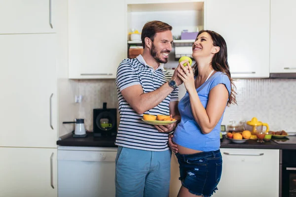 Беременная женщина с мужем на кухне — стоковое фото