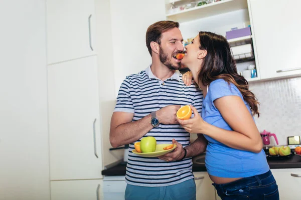 Pregnant woman with husband in the kitchen — Stock Photo, Image