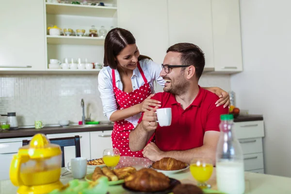 家でキッチンで朝食を持っている陽気な若いカップル. — ストック写真
