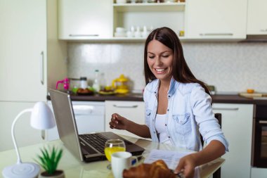 Dizüstü bilgisayar ve belge ile çalışan çekici genç kadın