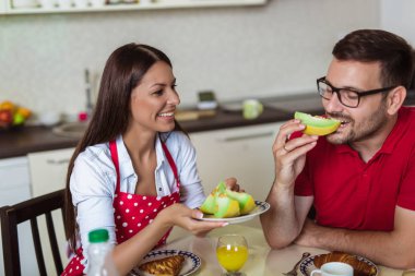 Neşeli genç çift mutfakta kahvaltı yapıyor.. 